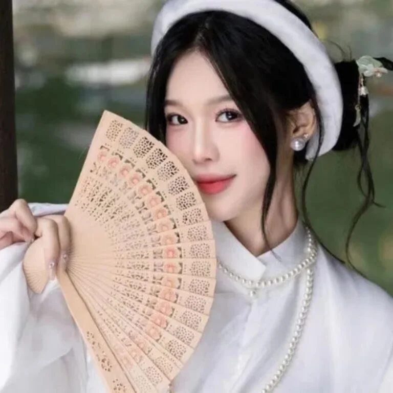 Gái đẹp Việt Nam mặc trang phục truyền thống cầm quạt gỗ chạm khắc