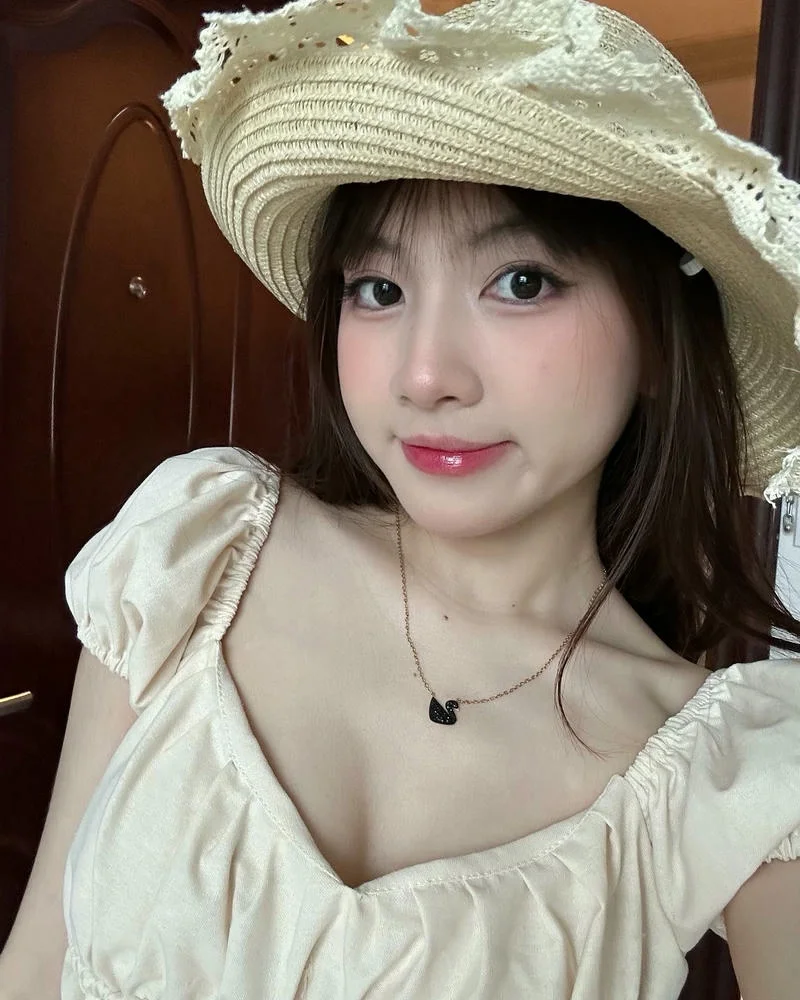 Ảnh chân dung gái đẹp Việt Nam mặc váy tay bồng màu kem và đội mũ rơm
