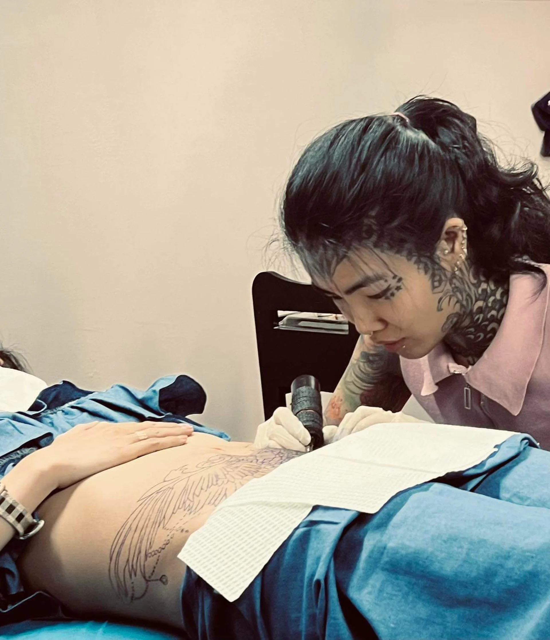 Nghệ nhân xăm hình đang thực hiện dịch vụ xăm vùng kín nữ chuyên nghiệp tại studio