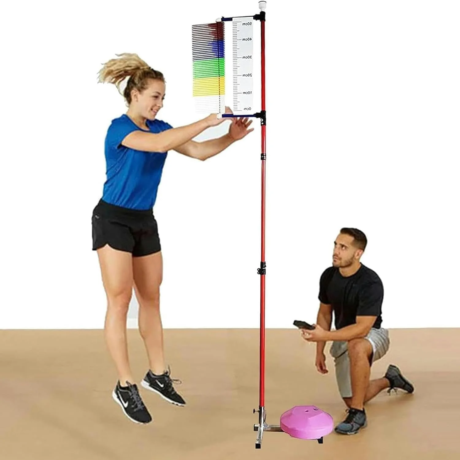 Nữ vận động viên áo xanh đứng bên dụng cụ tập luyện cùng huấn luyện viên