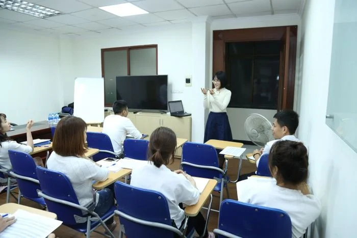 Hình ảnh lớp học nhỏ hiện đại với cô giáo đang đứng giảng bài cho học viên ngồi nghe chăm chú