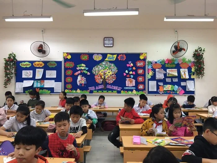 Hình ảnh lớp học tiểu học với học sinh ngồi ngay ngắn tại bàn học