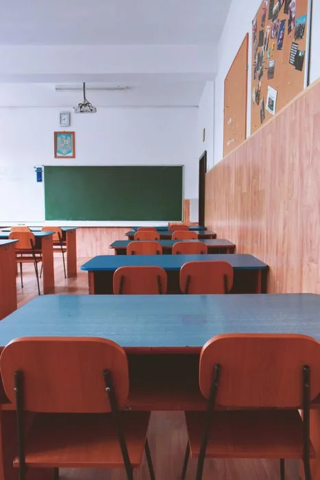 hình ảnh lớp học với dãy bàn xanh ghế đỏ xếp ngay ngắn