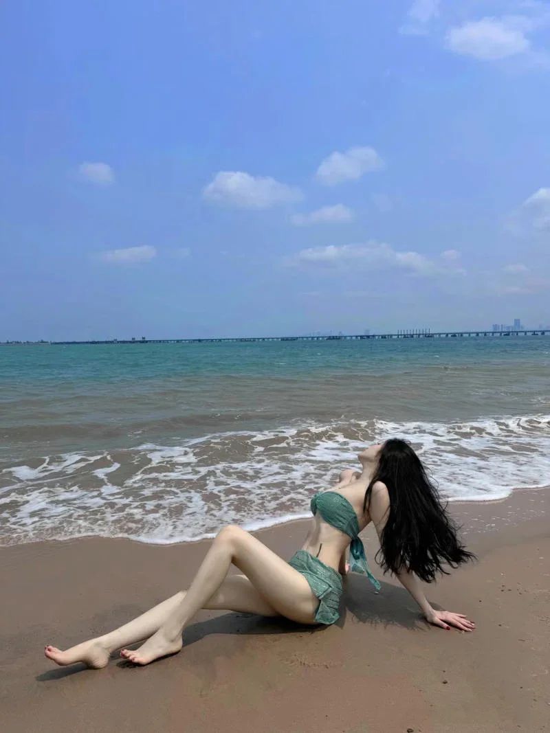Cô gái mặc bikini đi biển tạo dáng quyến rũ trên bãi cát