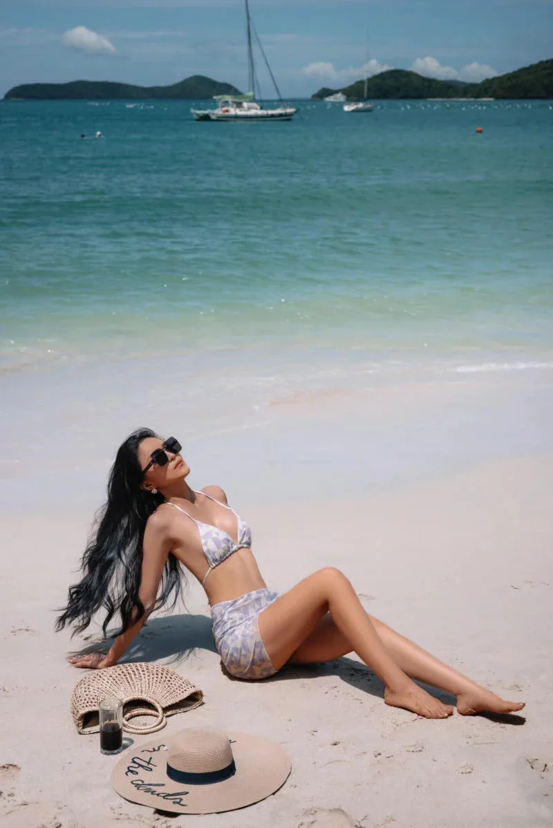 Cô gái quyến rũ mặc bikini đi biển tạo dáng trên bãi cát trắng